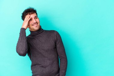 Kafkasyalı genç adam mavi arka planda yalnızdı gülerek, kaygısızca, doğal duygularla.