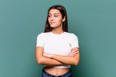 Genç Hintli kadın mavi arka planda izole edilmiş amaçlara ve amaçlara ulaşmayı hayal ediyor.