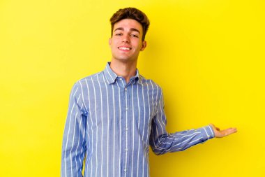 Sarı arka planda izole edilmiş beyaz bir genç hoş bir yüz ifadesi sergiliyor..