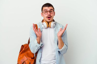 Beyaz arka planda izole edilmiş müzik dinleyen beyaz bir öğrenci şaşırmış ve şok olmuştu..