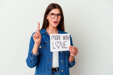 Beyaz arka planda izole edilmiş, tırnak yiyen, gergin ve tedirgin bir aşk levhası taşıyan beyaz bir kadın..