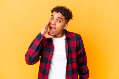 Genç Afro-Amerikalı kıvırcık adam, mor üzerine izole edilmiş, heyecanla bağırıyor..