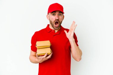 Beyaz arka planda izole edilmiş genç beyaz teslimatçı şaşırmış ve şok olmuş..