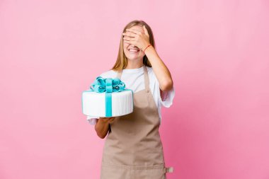 Lezzetli bir pasta tutan genç Rus fırıncı kadın elleriyle gözlerini kapatıyor, gülümseyerek büyük bir sürpriz bekliyor..