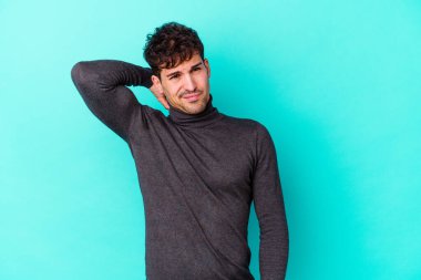 Kafkasyalı genç bir adam mavi arka planda izole edilmiş. Durağan yaşam tarzından dolayı boyun ağrısı çekiyor..