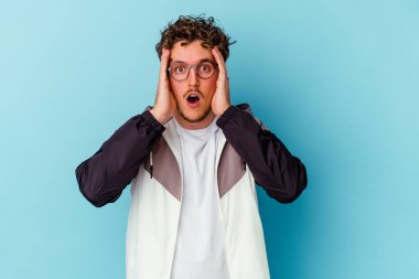 Mavi arka planda gözlüklü genç beyaz adam şoka uğruyor, önemli bir toplantıyı hatırlıyor..