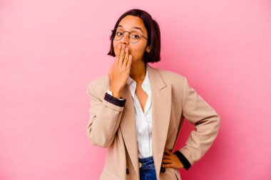 Pembe arka planda izole edilmiş genç iş kadını şok olmuş, ağzı ellerle kaplanmış, yeni bir şey keşfetmeye hevesli..