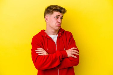 Sarı arka planda izole edilmiş genç beyaz adam tekrarlanan bir görevden bıktı..