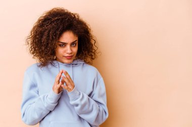 Genç Afrikalı Amerikalı kadın, bej arka planda izole edilmiş, bir fikir üretiyor..