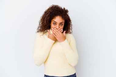 Beyaz arka planda izole edilmiş genç Afrikalı Amerikalı kadın elleriyle ağzını kapatırken şok oldu..