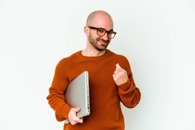 Beyaz arkaplanda dizüstü bilgisayar tutan genç kel bir adam sanki seni davet ediyormuş gibi seni işaret ediyor..