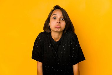 Sarı omuz silkme ve açık gözlerle izole edilmiş genç İspanyol kadın..