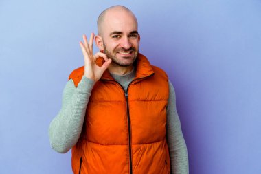 Kafkasyalı kel adam mor arka planda izole edilmiş neşeli ve kendinden emin..