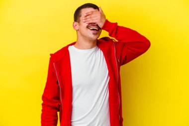 Sarı arka planda izole edilmiş beyaz bir adam ellerini başının üstünde tutarak neşe içinde gülüyor. Mutluluk kavramı.