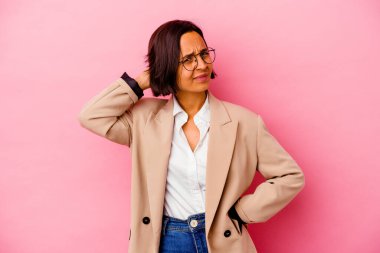 Genç iş kadını karışık ırk pembe arka planda izole edilmiş sabit yaşam tarzından dolayı boyun ağrısı çeken.