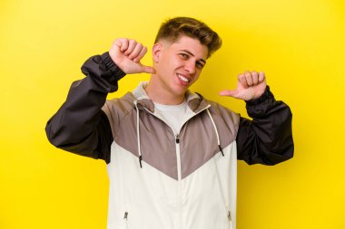Sarı arka planda izole edilmiş genç beyaz adam gururlu ve kendinden emin hissediyor, örnek olarak.