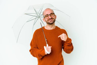 Elinde şemsiyesi olan genç kel bir adam gömlek fotokopi odasını elle gösteriyor, gururlu ve kendinden emin.