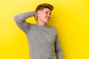 Sarı arka planda izole edilmiş genç beyaz adam sabit yaşam tarzından dolayı boyun ağrısından muzdarip..