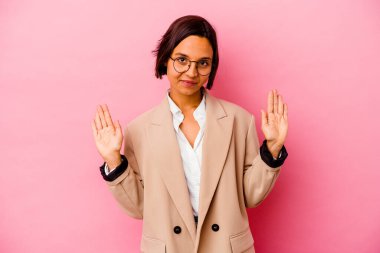 Pembe arka planda izole edilmiş genç iş kadını hoş bir sürpriz alıyor, heyecanlı ve el kaldırıyor..