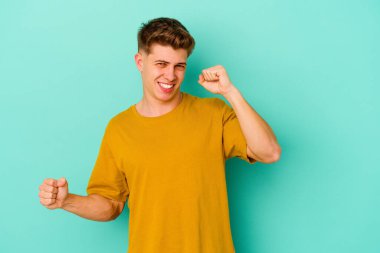 Genç beyaz adam mavi arka planda izole edilmiş dans ediyor ve eğleniyor..