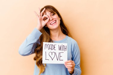 Genç, beyaz bir kadın aşk levhası taşıyor. Heyecanlı. Gözünü dört aç..