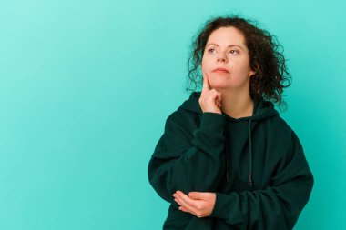 Down sendromlu bir kadın şüpheli ve şüpheci bir ifadeyle yan bakıyor..