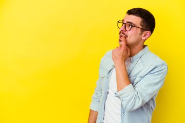 Sarı arka planda izole edilmiş beyaz bir adam rahatlamış bir şeyin fotokopi odasına baktığını düşünüyor..