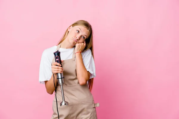 年轻的俄罗斯厨师女人抱着一个隔离的电动搅拌器 看着抄袭的空间 她感到悲伤和沉思 — 图库照片