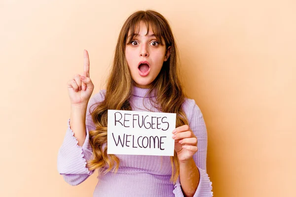 Young caucasian woman holding a Refugees welcome placard isolated having some great idea, concept of creativity.