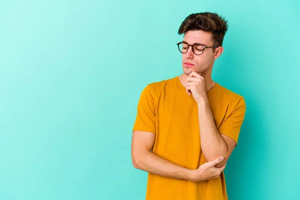 Jeune Homme Caucasien Isolé Sur Fond Bleu Regardant Latéralement Avec — Photo