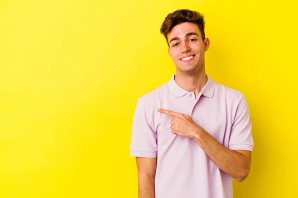 Joven Hombre Caucásico Aislado Sobre Fondo Amarillo Sonriendo Señalando Lado —  Fotos de Stock