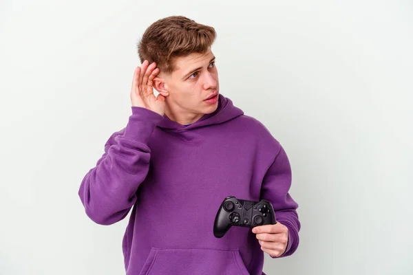 Jovem Caucasiano Segurando Gamepad Isolado Fundo Branco Tentando Ouvir Uma — Fotografia de Stock