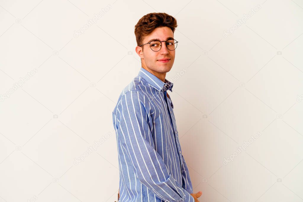 Young student man isolated on white background looks aside smiling, cheerful and pleasant.