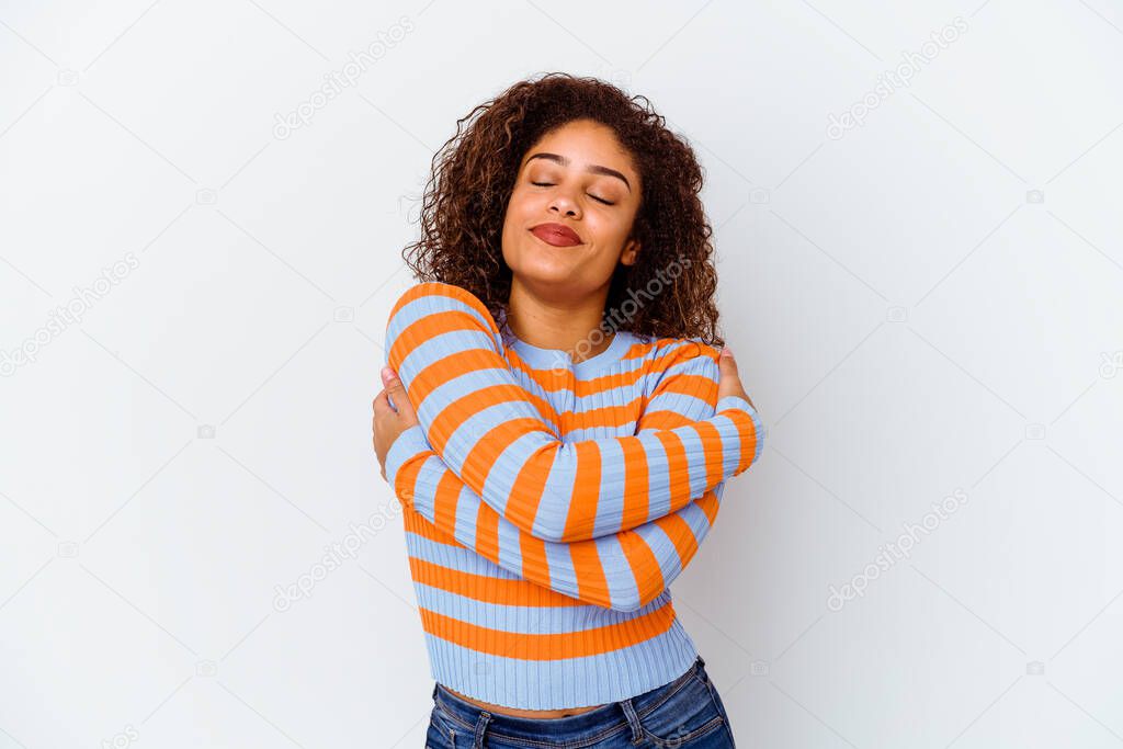 Young african american woman isolated on white background hugs, smiling carefree and happy.