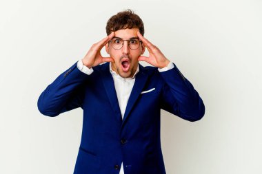 Beyaz arka planda izole edilmiş genç beyaz bir adam yüzünün yarısını palmiye ile kaplayarak eğleniyor..