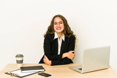 Masaüstünde çalışan beyaz bir iş kadını yalnız gülüyor ve eğleniyor..