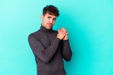 Kafkasyalı genç adam mavi arka planda izole edilmiş korkmuş ve korkmuş..