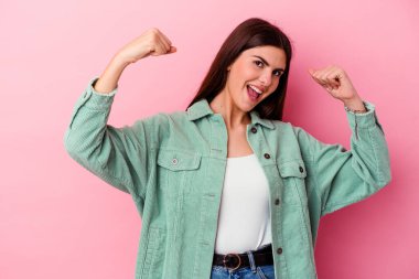 Pembe arka planda izole edilmiş beyaz bir kadın zaferden sonra yumruğunu kaldırıyor, kazanan konsept.