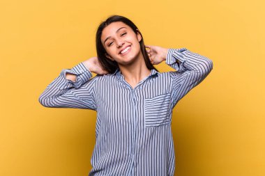 Sarı arka planda izole edilmiş genç bir Hintli kadın. Kollarını uzatıyor, rahat duruyor..