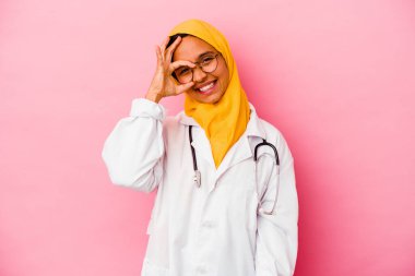 Genç doktor müslüman kadın, pembe arka planda izole edilmiş, heyecanlı..