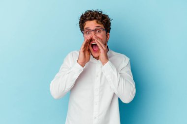Kafkasyalı genç iş adamı mavi arka planda izole edilmiş ve heyecanlı bir şekilde bağırıyor..