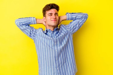 Sarı arka planda izole edilmiş genç beyaz adam sabit yaşam tarzından dolayı boyun ağrısından muzdarip..