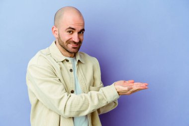 Kafkasyalı kel bir adam mor arka planda izole edilmiş. Elinde palmiye ağacında bir kopyası var..