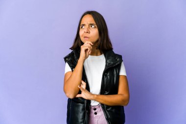 Genç melez kadın şüpheli ve şüpheci bir ifadeyle yan bakıyor..