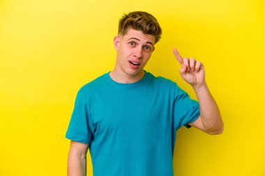 Sarı arka planda izole edilmiş genç beyaz bir adam harika bir fikri, yaratıcılık kavramı var..