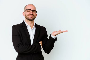 Genç, beyaz, kel bir adam mavi arka planda izole edilmiş bir şekilde bir avuç içinde fotokopi alanı ve belinde bir el daha gösteriyor..