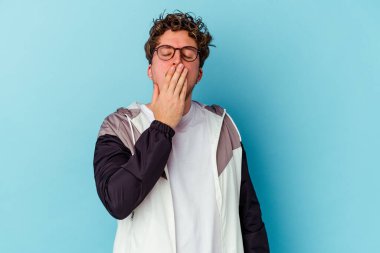 Mavi arka planda gözlüklü genç beyaz adam şok olmuş, ağzı ellerle kaplanmış, yeni bir şey keşfetmeye hevesli..