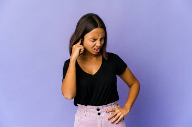 Genç melez kadın elleriyle kulaklarını kapatıyor..