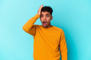 Genç Afro-Amerikan Kıvırcık Adam mavi üzerine izole edilmiş şokta, önemli bir toplantıyı hatırladı..