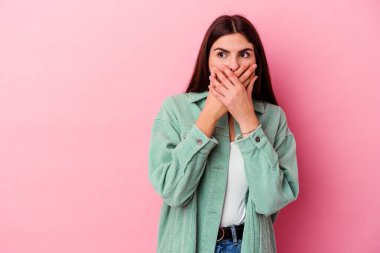Pembe arka planda izole edilmiş beyaz bir kadın. Düşünceli bir şekilde ağzıyla ağzını kapatan bir fotokopi odasına bakıyor..